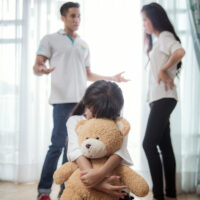 parents arguing in front of daughter who buries herself in stuffed bear parents arguing in front of daughter who buries herself in stuffed bear