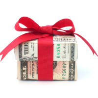 Dollar wrapped gift box with a red ribbon bow