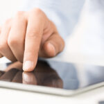 Man clicking on an iPad Man clicking on an iPad