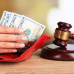 Hand holding money and a gavel Hand holding money and a gavel