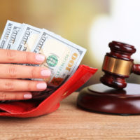 Hand holding money and a gavel Hand holding money and a gavel