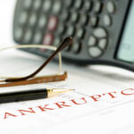 Calculater with a paper that reads Bankruptcy Calculater with a paper that reads Bankruptcy