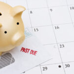 piggy bank sitting on a calendar piggy bank sitting on a calendar