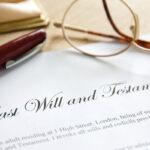 Last Will and Testament document with glasses and pen on table Last Will and Testament document with glasses and pen on table