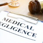 Clipboard with documents about medical negligence on a table Clipboard with documents about medical negligence on a table