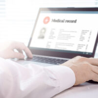 Doctor accesses electronic health records on laptop Doctor accesses electronic health records on laptop