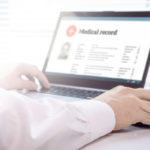 Doctor accesses electronic health records on laptop Doctor accesses electronic health records on laptop