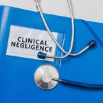 clinical negligence blue folder with stethoscope on top clinical negligence blue folder with stethoscope on top