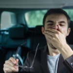drowsy driver yawning with hand to mouth drowsy driver yawning with hand to mouth