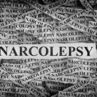 Torn pieces of paper with the words Narcolepsy