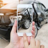 female hold mobile smartphone photographing car accident female hold mobile smartphone photographing car accident