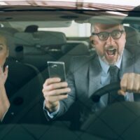 accident in car . man and woman using cellphone while driving car