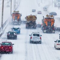 Tree Lined-up Snowplows Clearing the Highway