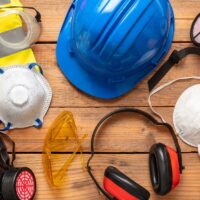 Work health and safety for industry and construction site. Labor personal protective gear flat lay. Protection equipment on wooden background, banner Work health and safety for industry and construction site. Labor personal protective gear flat lay. Protection equipment on wooden background, banner