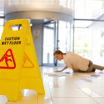 Businessman slipping on wet office floor
