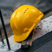 Construction hard hat safety tools equipment for workers in construction site for engineering protection head standard on building construction background. Yellow helmet