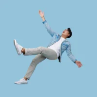 excited asian man relaxing floating in mid-air isolated on blue copy space background.